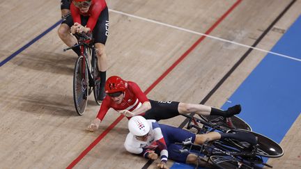 Frederik Madsen (en rouge) et Charlie Tanfield (en blanc) se sont percutés pendant l'épreuve de poursuite par équipes, à Tokyo le 3 août 2021. (ODD ANDERSEN / AFP)