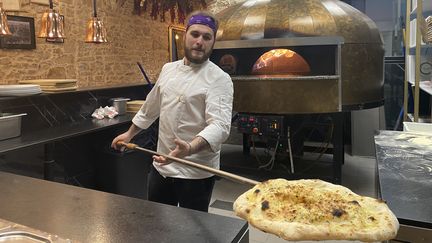 Le pizzaïolo Nando travaille à côté d'un four à 330°C pendant les fortes chaleurs, le 21 août 2023 à Lyon (Rhône). (PAOLO PHILIPPE / FRANCEINFO)