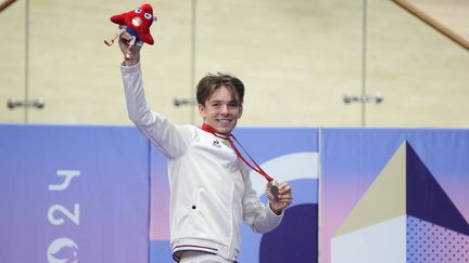 Le paracycliste sur piste Gatien Le Rousseau brandit sa Phryge en peluche après avoir reçu sa médaille de bronze de la poursuite individuelle C4 aux Jeux paralympiques de Paris, le 31 août 2024 à Saint-Quentin-en-Yvelines (Yvelines). (LECOCQ CEDRIC / KMSP / AFP)