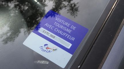 Un autocollant sur un pare brise de voiture de tourisme avec chauffeur. (Illustration).&nbsp; (JEAN FRANCOIS FREY / MAXPPP)