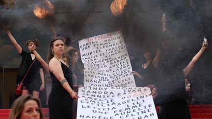 Peu avant l’arrivée de l’équipe du film "Holy Spider" de l'iranien Ali Abbasi, la montée des marches est sous le signe de l’engagement. Une partie du collectif du&nbsp;documentaire «&nbsp;Riposte Féministe&nbsp;» de Marie Perennès et Simon Depardon, ont déroulé une banderole avec les noms des 129 victimes des féminicdes en France depuis le dernier Festival de Cannes. (PATRICIA DE MELO MOREIRA / AFP)