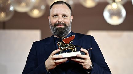 Le réalisateur Yorgos Lanthimos pose avec le Lion d'or du meilleur film qu'il a reçu pour "Pauvres créatures" lors d'une séance photo pour les gagnants au 80e Festival du Film de Venise (Mostra) le 9 septembre 2023 au Lido de Venise (GABRIEL BOUYS / AFP)