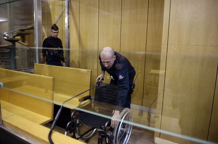 Un pompier installe la chaise du capitaine Simbikangwa, le 4 f&eacute;vrier 2014, au tribunal de grande instance de Paris. (MARTIN BUREAU / AFP)