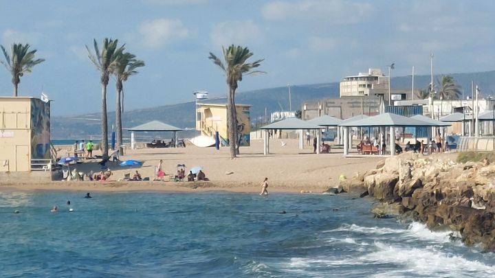 La plage principale de la ville israélienne de Nahariya, avec la montagne bordant le Liban et les positions du Hezbollah en arrière-plan, à 9 km. (ERIC AUDRA / RADIOFRANCE)