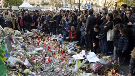 Des Parisiens rendent hommage aux victimes des attentats du 13 novembre, près du Bataclan, le 15 novembre 2015. (MIGUEL MEDINA / AFP)