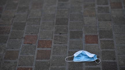 Un masque de protection contre le Covid-19 abandonné dans une rue de Leicester, dans le centre de l'Angleterre, le 29 juin 2020. (BEN STANSALL / AFP)