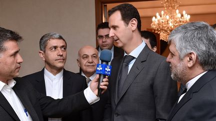 Le pr&eacute;sident syrien, Bachar&nbsp;Al-Assad, r&eacute;pond, le 16 mars 2015, aux questions d'un journaliste iranien apr&egrave;s une rencontre avec le minist&egrave;re de l'Economie et des Finances iranien, &agrave; Damas (Syrie). ( SANA / AFP)