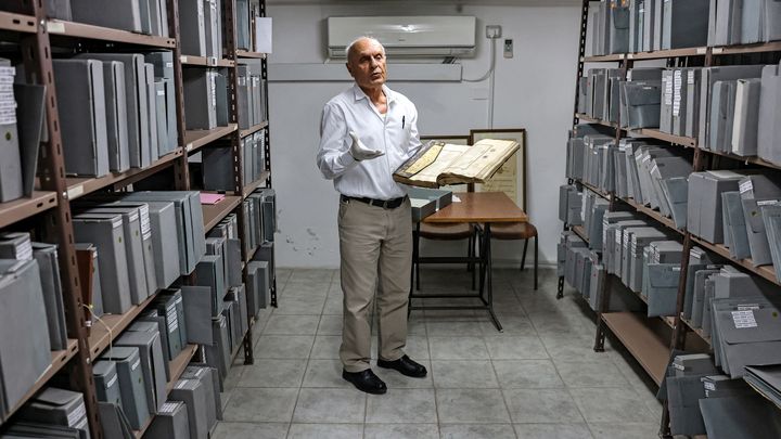 A Khalidi, le responsable des collections Khader Salameh présente une copie dorée du Coran. (AHMAD GHARABLI / AFP)