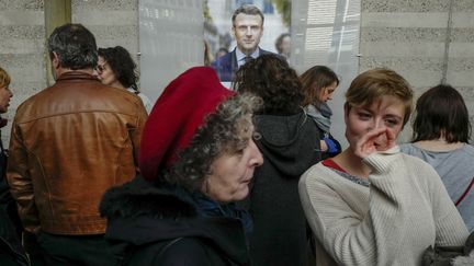 Des électeurs français patientent devant les affiches électorales, avant de pouvoir voter pour le premier tour de l'élection présidentielle, à l'ambassade de France à Berlin (Allemagne), le 23 avril 2017. (JOHN MACDOUGALL / AFP)