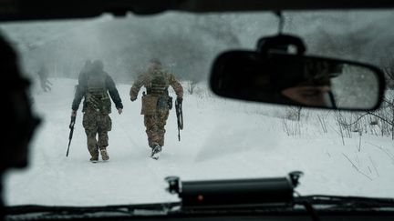 Ukraine, 18 février 2023. Des militaires de l'unité ukrainienne Vedmak patrouillent dans le blizzard, le long de la ligne de front, près de Bakhmut. (YASUYOSHI CHIBA / AFP)