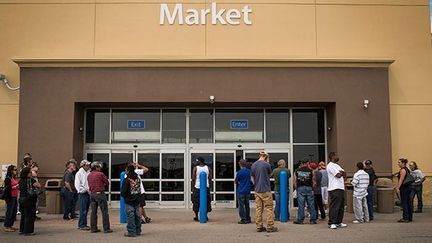 Le parking de l’hypermarché est souvent un lieu de rendez-vous pour ceux qui viennent d’arriver.
 
La demande est telle que le personnel ne prend plus la peine de ranger les produits dans les rayons. Les clients se servent directement sur les palettes.  (Andrew Burton / Getty Images / AFP)