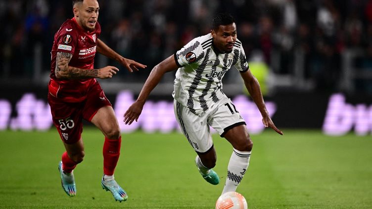 Alex Sandro with the ball against Lucas Ocampos in the Europa League semi-final first leg between Juventus and Sevilla FC on Thursday 11 May.  (MARCO BERTORELLO / AFP)