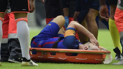 Andres Iniesta, sorti sur civière lors du match Valence-Barcelone après une blessure au genou droit. (JOSE JORDAN / AFP)