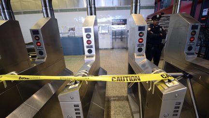 La station de m&eacute;tro&nbsp;Times Square, &agrave; New York,&nbsp;est ferm&eacute;e et gard&eacute;e par un policier, lundi 29 octobre 2012.&nbsp; (TIMOTHY A. CLARY / AFP)