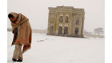 Kaboul, 5 janvier 2008. Un Afghan marche dans la neige devant un bâtiment en ruine. Photographe afghan âgé de 30 ans, Massoud Hossaini témoigne des évolutions de la guerre dans son pays depuis 2007
 (Massoud Hossaini / AFP)