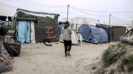 Un migrant marche à travers la "jungle", le 7 octobre 2016, à Calais (Pas-de-Calais). (PHILIPPE HUGUEN / AFP)