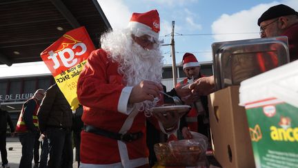 Des militants de la CGT partagent un repas devant la gare de Fleury-les-Aubrais (Loiret), le 23 décembre 2019. (GUILLAUME SOUVANT / AFP)