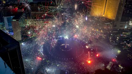 Les feux d'artifice&nbsp;illuminent le monument Selamat Datang, à Jakarta (Indonésie). (BAY ISMOYO / AFP)