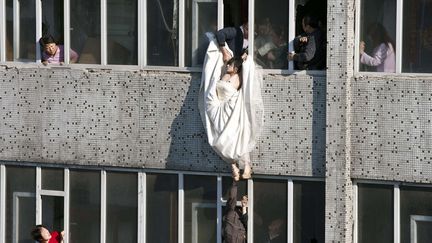 Sauvetage d'une femme en robe de mari&eacute;e qui tentait de se suicider &agrave; Changchun (Chine), le 17 mai 2011. (REX / SIPA)