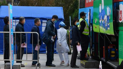 A Pékin, les habitants font la queue pour se faire vacciner contre le Covid-19 dans un bus, le 7 avril 2021. (GREG BAKER / AFP)