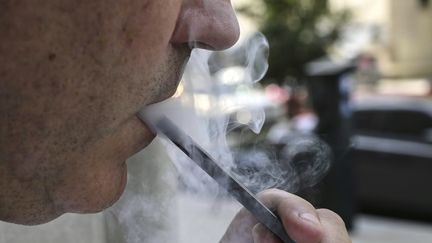 Un homme vapote dans la rue à Washington, aux Etats-Unis, le 12 septembre 2019. (EVA HAMBACH / AFP)