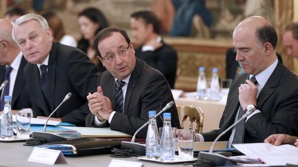 Fran&ccedil;ois Hollande, entour&eacute; de Jean-Marc Ayrault (&agrave; gauche) et Pierre Moscovici (&agrave; droite), lors d'un s&eacute;minaire organis&eacute; &agrave; l'Elys&eacute;e, &agrave; Paris, le 29 mai 2013. (CHARLES PLATIAU / AFP)