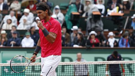 Rafael Nadal banalise le succès. Huitième participation à Roland-Garros et septième sacre, cette fois ci face à Novak Djokovic (6-4, 6-3, 2-6, 7-5), le 11 juin 2012. Commencée la veille et interrompue par la pluie, la finale se termine le lundi. (THOMAS COEX / AFP)