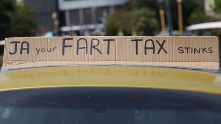 Un message&nbsp;contre le projet du gouvernement néo-zélandais de taxer les émissions de gaz à effet de serre du bétail, le 20 octobre 2022, à Wellington (Nouvelle-Zélande).&nbsp; (MARTY MELVILLE / AFP)