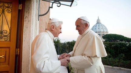 Le pape émérite Benoît XVI (à gauche) accueille son sucesseur, François, le 23 décembre 2019 au Vatican. Le premier avait annoncé en février sa renonciation, une première pour l'Eglise depuis 1415. (L'OSSERVATORE ROMANO / AP / SIPA)