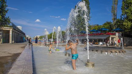 Des enfants se rafraîchissent dans une fontaine de la place de Stalingrad, à Paris, le 10 août 2020. (LP/YANN FOREIX / MAXPPP)