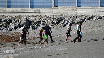 Des migrants en provenance du Maroc et&nbsp;des gardes civils espagnols sur une plage de l'enclave espagnole de Ceuta, le 17 mai 2021.&nbsp; (ANTONIO SEMPERE / AFP)