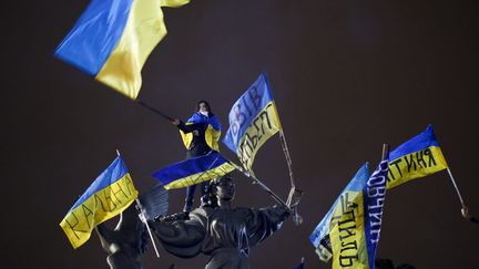 Une manifestante pro-europ&eacute;enne agite un drapeau ukrainien place de l'Ind&eacute;pendance &agrave; Kiev (Ukraine), le 15 d&eacute;cembre 2013. (MARKO DJURICA / REUTERS)