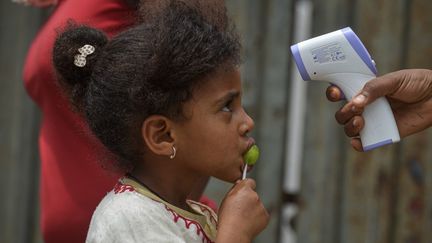 Une enfant éthiopienne dont la température est mesurée durant une campagne de prévention contre le coronavirus à Addis-Abeba, le 20 avril 2020. (MICHAEL TEWELDE / AFP)