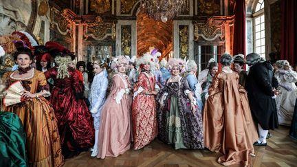 En costumes d'époque, les participants des "Fêtes Galantes" déambulent dans le château de Versailles (LUDOVIC MARIN / AFP)