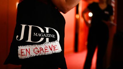 Une femme porte un sac soutenant la grève au "JDD" lors d'une soirée organisée par Reporters sans frontières au Théâtre libre, à Paris, le 27 juin 2023. (CHRISTOPHE ARCHAMBAULT / AFP)