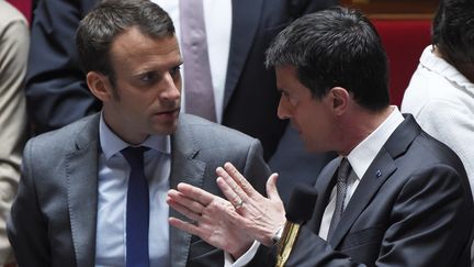 Manuel Valls discute avec Emmanuel Macron, le 9 juin 2015, à l'Assemblée nationale, à Paris. (DOMINIQUE FAGET / AFP)