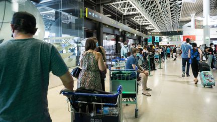 Des voyageurs attendent dans l'aéroport de Lisbonne (Portugal), le 17 juillet 2021. (ANDRE ALVES / ANADOLU AGENCY / AFP)