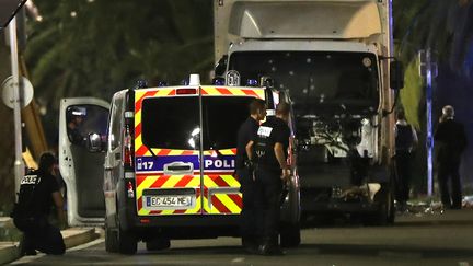 Des policiers sur la promenade des Anglais, à Nice (Alpes-Maritimes), à proximité du camion meurtier qui a tué 84 morts, le 14 juillet 2016. (VALERY HACHE / AFP)