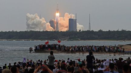 Des curieux assistent au lancement du premier module de la station spatiale chinoise,&nbsp;le 29 avril 2021 à Wenchang (Chine). (KOKI KATAOKA / YOMIURI / AFP)