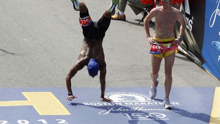 Le coureur Remus Medley (G), pris de crampes dans les jambes,&nbsp;termine le marathon de Boston (Massachusetts) sur les mains, le 16 avril 2012. (JESSICA RINALDI / REUTERS)