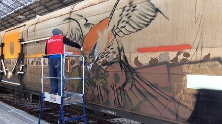 Un graffeur repeint le train "Rungis" à la gare d'Austerlitz à Paris, samedi 22 octobre 2016. (WILFRIED DEMARET)