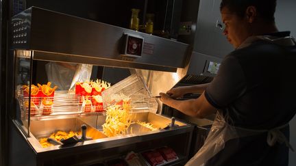 Un employé de Mc Donald's prépare des frites dans une enseigne des Champs-Elysées, à Paris, le 19 février 2016. (NICOLAS KOVARIK / MAXPPP)