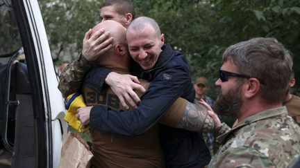 Un soldat ukrainien retrouve des proches après avoir été libéré à l'occasion d'un échange de prisonniers entre la Russie et l'Ukraine, près de la frontière entre l'Ukraine et la Biélorussie, le 13 septembre 2024. (ANATOLII STEPANOV / AFP)