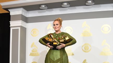 Adele avec ses cinq récompenses obtenues à la 59e cérémonie des Grammy Awards, le 12 février 2017 à Los Angeles (Etats-Unis). (ROBYN BECK / AFP)