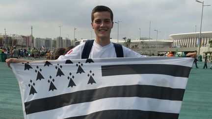 Clément Berder présente fièrement son drapeau dans le parc olympique, à Rio de Janeiro (Brésil), le 8 août 2016. (PIERRE GODON / FRANCETV INFO)