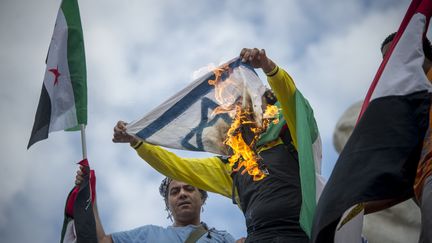 Des manifestants pro-palestiniens br&ucirc;lent un drapeau isra&eacute;lien place de la R&eacute;publique, &agrave; Paris, le 26 juillet 2014. (ZACHARIE SCHEURER / AFP)