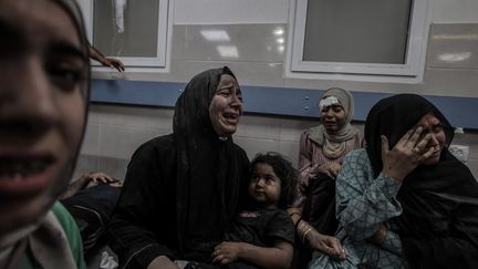 Des Palestiniennes, blessées, pleurent après la frappe meurtrière sur l'hôpital Ahli Arab à Gaza, le 17 octobre 2023. (ALI JADALLAH / ANADOLU / AFP)