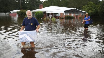 Des habitants évacuent leurs affaires de leur maison de Spring Lake, en Caroline du Nord, pour fuir la montée des eaux sur le passage de la dépression tropicale Florence, le 17 septembre 2018. (JOE RAEDLE / AFP)