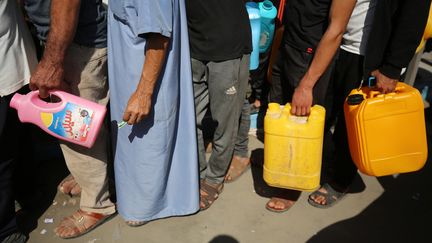 Des Palestiniens font la queue avec des jerrycans dans une station-service de la ville de Gaza, le 19 octobre 2023, au milieu des combats en cours entre Israël et le groupe palestinien Hamas. (MAJDI FATHI / NURPHOTO)