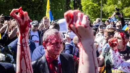 L'ambassadeur russe en Pologne, Sergueï Andreev, recouvert de faux sang à Varsovie le 9 mai 2022 (WOJTEK RADWANSKI / AFP)